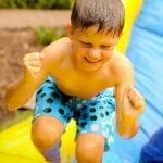 An excited child playing in water at a birthday party